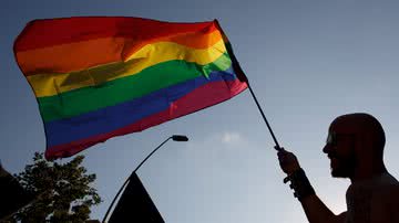 Pessoa segurando bandeira do orgulho LGBTQIAP+ - Getty Images
