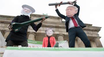 Atores vestidos como líderes religiosos Ali Chamenei, Angela Merkel e Donald Trump realizam uma ação de teatro de rua como parte de uma manifestação anti-guerra - Getty Images