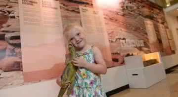 Lily com dinossauro de brinquedo no Museu - Divulgação / Museu Nacional de Cardiff
