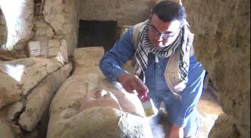 Arqueólogo limpando um dos sarcófagos - Divulgação/ YouTube/ Al Jazeera English