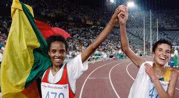 Bicampeã no atletismo, a etíope Derartu Tulu, à esq., celebra a vitória com a prata sul-africana Elana Meyer em Barcelona, 1992 - Pascal PAVANI / AFP