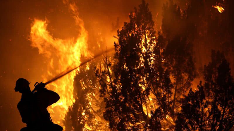 Imagem de um bombeiro lutando contra as chamas de um incêndio no Canadá - Getty Images