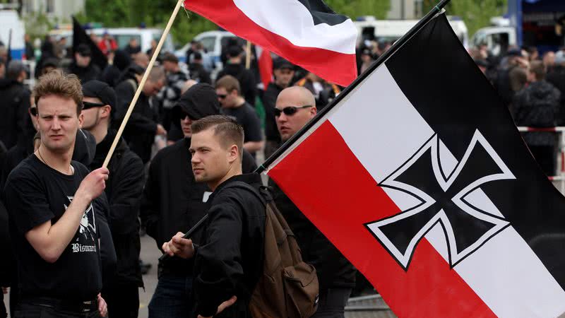 Fotografia de manifestante neonazista alemão com bandeira da Alemanha Imperial - Getty Images