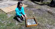Arqueóloga ao lado de artefatos encontrados no antigo cemitério de Zion - Divulgação/Youtube