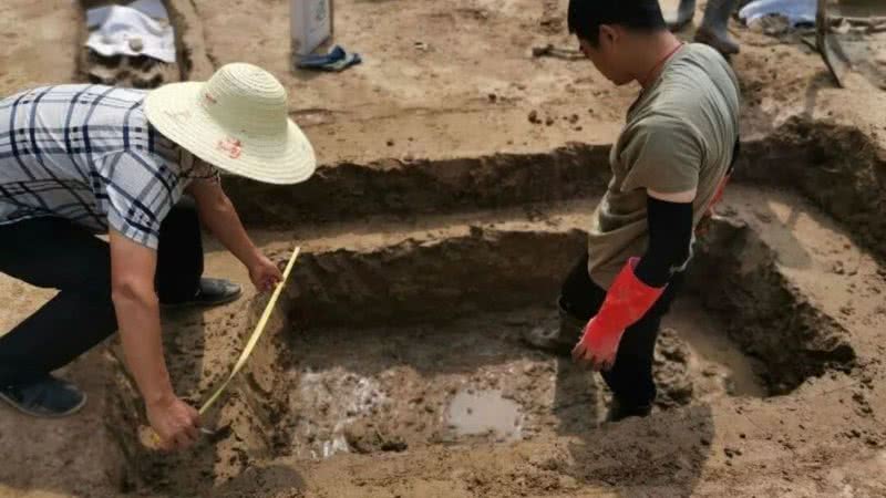Arqueólogos medem uma das covas encontradas próximas ao rio - Divulgação
