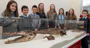 Alunos da escola Ysgol Bodringalt com o esqueleto do crocodilo - Divulgação/Conselho Rhondda Cynon Taf