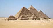Fotografia das três pirâmides de Gizé, a maior delas no meio. - Wikimedia Commons