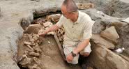 Pesquisador analisando tumba em Lijiang, China - Divulgação/Yunnan Daily