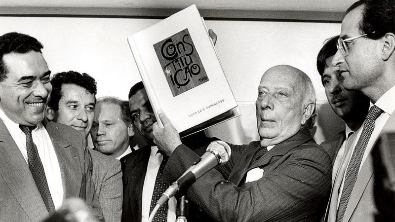 Ulysses Guimarães com uma cópia da Constituição de 1988 em suas mãos - Célio Azevedo via Agência Brasil