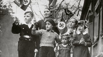 Crianças alemãs com bandeiras nazistas - Getty images