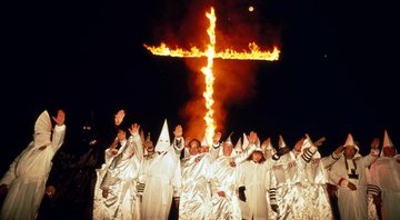 Membros da Klu Klux Klan queimando uma cruz - Getty Images