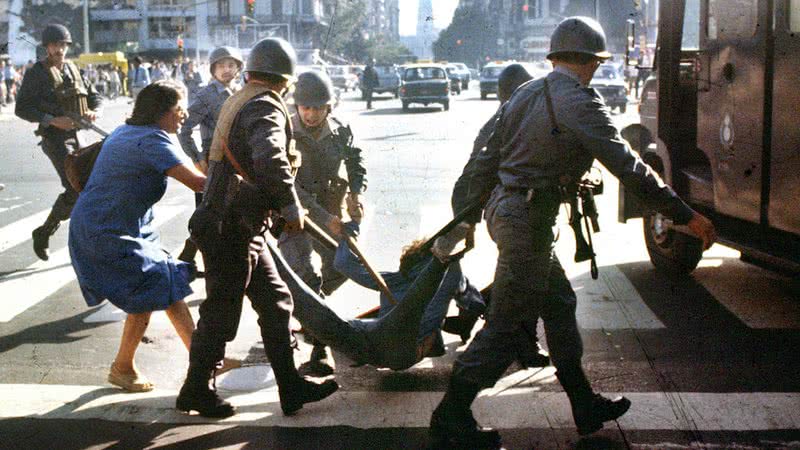 Mulher tenta impedir a detenção de um jovem pela polícia durante a ditadura militar Argentina  (1976-1983) - Getty Images
