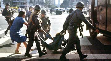 Mulher tenta impedir a detenção de um jovem pela polícia durante a ditadura militar Argentina  (1976-1983) - Getty Images