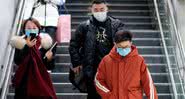 Chineses com máscaras faciais para a prevenção do vírus - Getty Images