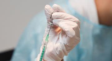 Profissional da saúde prepara uma seringa para vacinar paciente - Getty Images