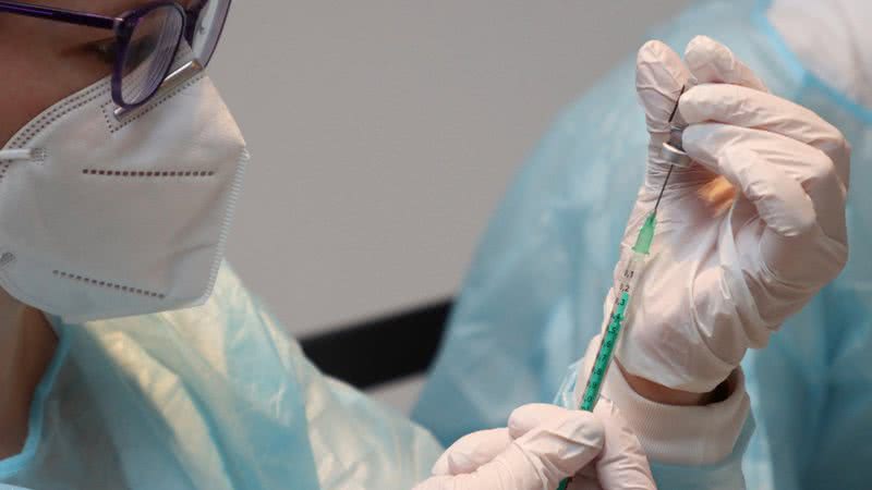 Profissional da saúde prepara uma seringa para vacinar paciente - Getty Images