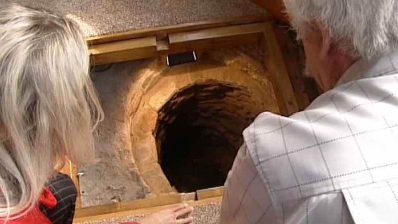 Colin e a esposa observam o profundo poço medieval - Divulgação/BBC News/30.08.2012