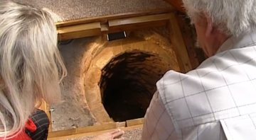 Colin e a esposa observam o profundo poço medieval - Divulgação/BBC News/30.08.2012