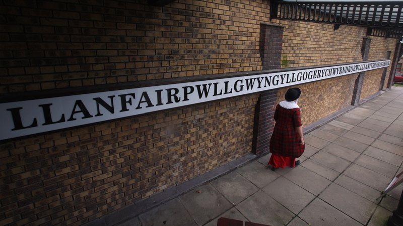 Placa com o nome completo de Llanfairpwllgwyngyllgogerychwyrndrobwllllantysiliogogogoch - Getty Images