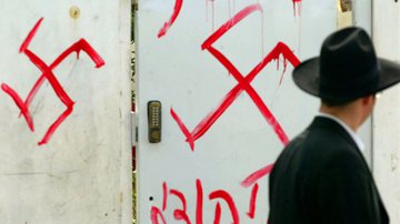 Judeu observa uma pichação antissemita em Petah Tikva, perto de Tel Aviv, no centro de Israel - Getty Images