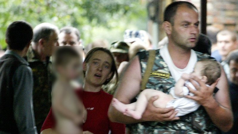 Pessoas sendo resgatadas da escola no massacre de Beslan