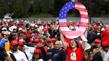 Membro do QAnon segurando um 'Q' enorme em evento pró-Trump em 2018 - Getty Images