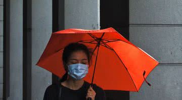 Imagem ilustrativa de uma mulher usando máscara na rua - Unsplash