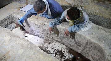 O egiptólogo Ramadan Hussein (à esquerda) e a especialista em múmias Salima Ikram examinam um sarcófago de calcário em Sacará - Ministério do Turismo e Antiguidades do Egito