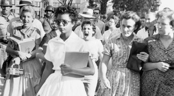 Elizabeth Eckford caminhando para Little Rock Central High School, enquanto Hazel Bryan está atrás dela gritando - Wikimedia Commons