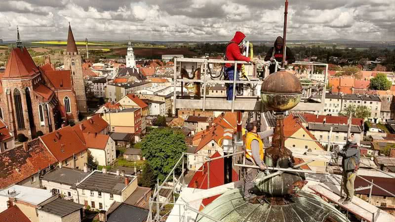 Trabalhadores no topo da igreja de Ziebice, na Polônia - Divulgação