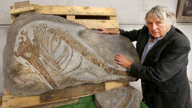 Julian Temperley e o fóssil do ictiossauro / Crédito: Richard Austin / SWNS