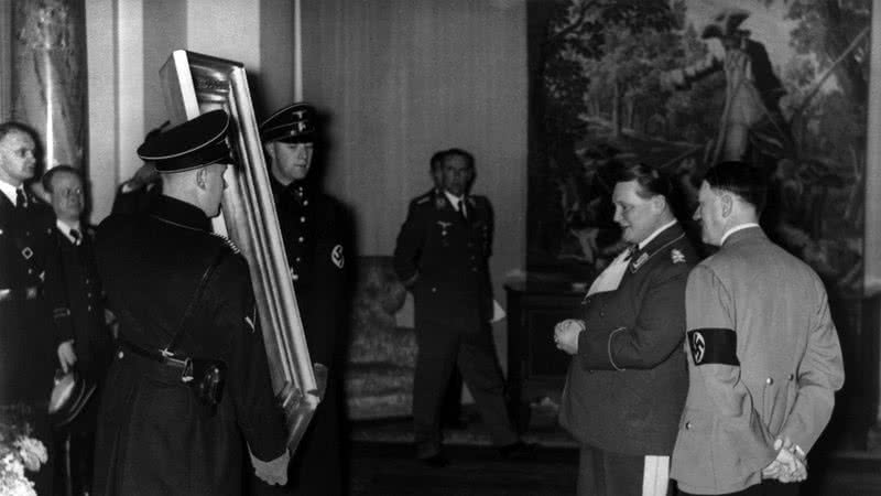 Hermann Goering mostra uma pintura confiscada ao líder alemão Adolf Hitler por volta de 1940 - Getty Images