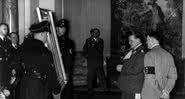 Hermann Goering mostra uma pintura confiscada ao líder alemão Adolf Hitler por volta de 1940 - Getty Images