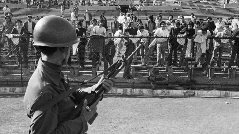 Um soldado do Exército chileno vigia prisioneiros políticos mantidos no Estádio Nacional de Santiago - Getty Images