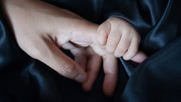 Imagem ilustrativa de uma pessoa segurado a mão de um bebê - Foto de bingngu93, via Pixabay