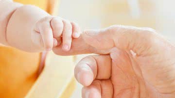Imagem ilustrativa de bebê segurando a mão de um adulto - Foto de RitaE, via Pixabay