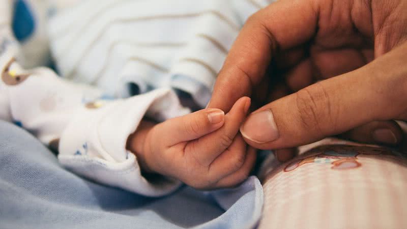 Imagem ilustrativa da mão de um bebê com a mão de um adulto - Foto de Pexels, via Pixabay