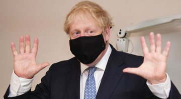 Boris Johnson usa máscara e levanta as mãos - Getty Images