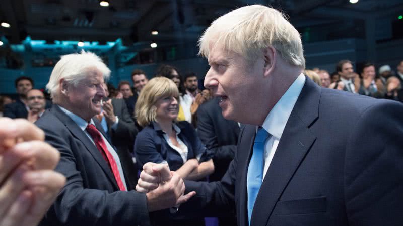 Boris Johnson (dir.) aperta a mão de seu pai, Stanley Johnson (esq.), durante evento - Getty Images