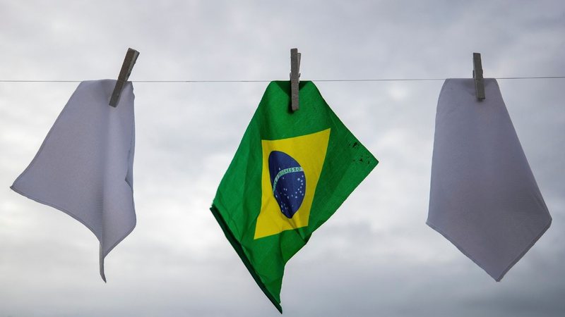 Bandeira do Brasil disposta junto de bandeiras brancas