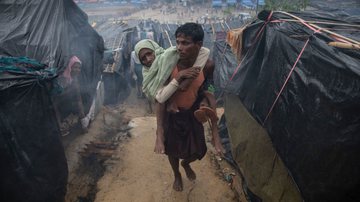 Homem rohingya carrega sua mãe deficiente no campo de refugiados de Cox's Bazar, no Bangladesh, em 2017 - Paula Bronstein/Getty Images