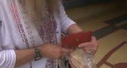 A proprietária da carteira com o objeto em mãos, 46 anos depois de ter perdido - Divulgação/YouTube/ CBS Los Angeles