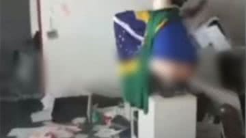 Trecho de vídeo de homem com bandeira do brasil nas costas e de calças abaixadas em cima de mesa na Suprema Corte - Reprodução / Vídeo