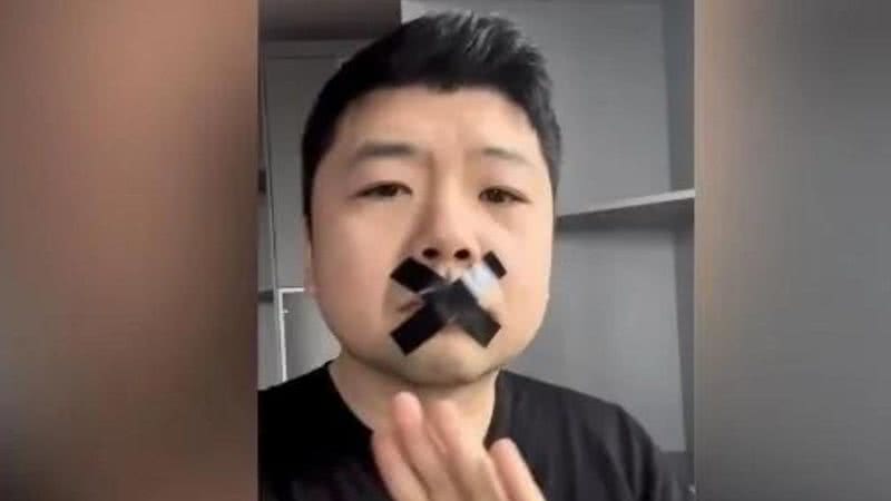 Wang Jixian com fita na boca sinalizando censura