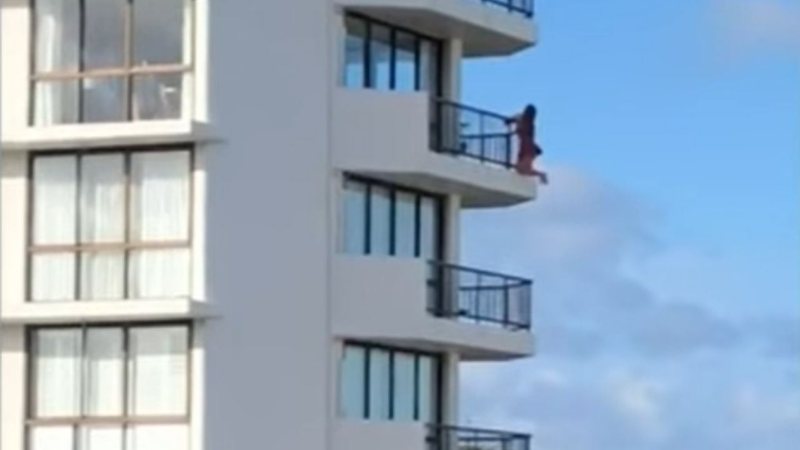 Trecho do vídeo, mostrando mulher no exterior da grade da sacada - Divulgação/ Facebook