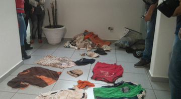 Pessoas observam roupas encontradas na casa do pintor - Divulgação / G1