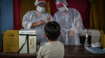 Criança aguarda vacina - Getty Images