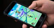 Pessoa joga Pokémon Go em smartphone - Getty Images