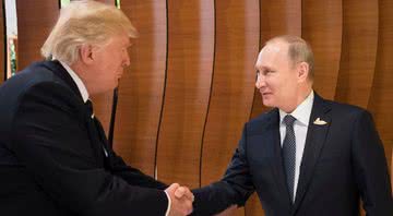 Putin e Trump apertam as mãos - Getty Images