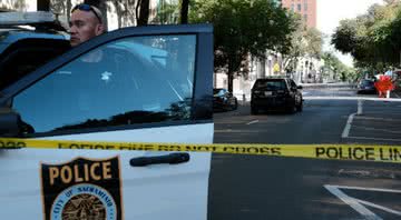 Policial entra em carro em área isolada onde ocorreu o tiroteio - Getty Images